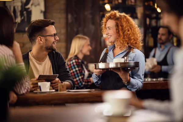 Happy Waitress Communicating Young Man While Brining Order His Table — Stockfoto