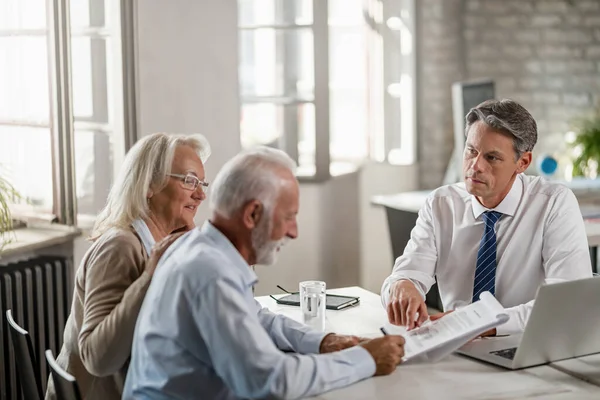 Senior Couple Signing Contract While Being Meeting Bank Manager Focus — Fotografia de Stock