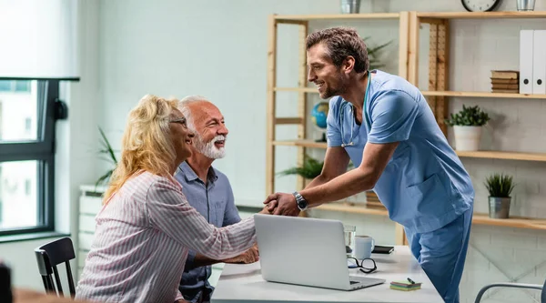 Happy Doctor Greeting Senior Couple Shaking Hands Woman His Office — Foto de Stock