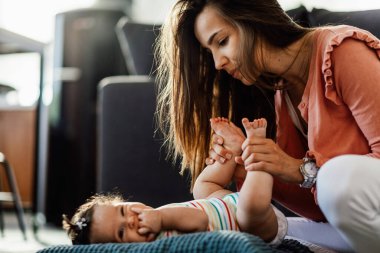 Young woman enjoying in time she's spending with her cute baby girl at home.