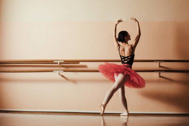 Full length of ballerina rehearsing in a ballet studio. 