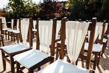 Decorated chairs at wedding ceremony. 