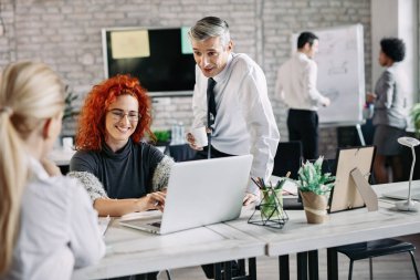 Happy business people talking to each other while working in the office. 