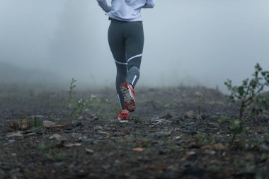 Back view of unrecognizable runner jogging in nature misty morning. 