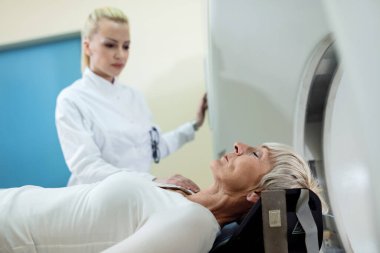 Mature female patent about to have CT scan examination at clinic. 