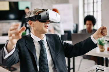 Businessman wearing virtual reality headset and having fun on a break in the office. 