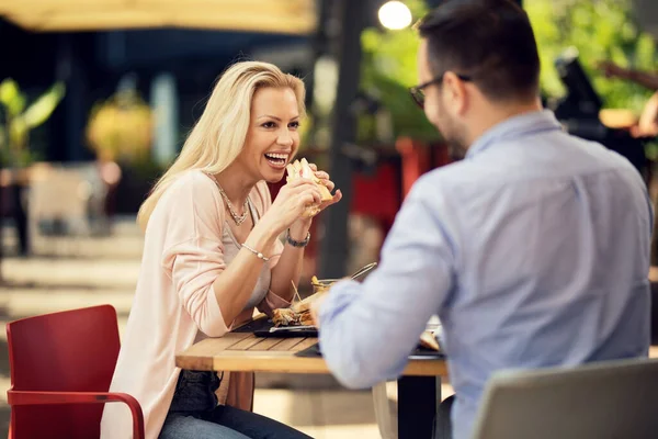 Happy Woman Talking Her Boyfriend While Eating Sandwich Outdoor Restaurant — Zdjęcie stockowe