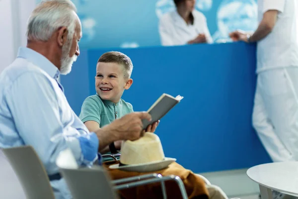 Happy Little Boy His Grandfather Reading Book Communicating While Waiting — Fotografia de Stock