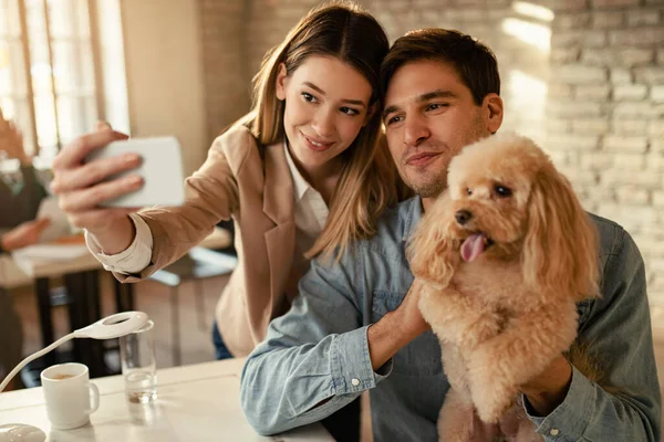 Young Business Couple Using Smart Phone Taking Selfie Dog Office —  Fotos de Stock