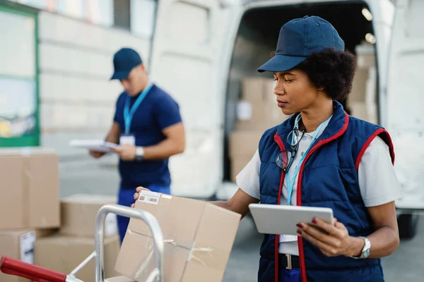 Black Female Worker Using Digital Tablet While Doing Package Inventory — Foto Stock
