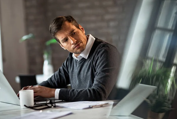 Mid Adult Entrepreneur Working Computer Looking Away While Feeling Dissatisfied — Photo