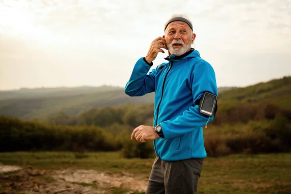 Smiling Senior Sportsman Listening Music While Getting Ready Run Nature — Stockfoto