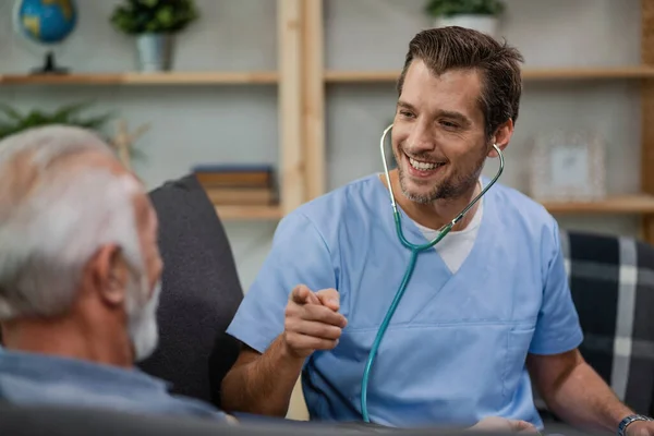 Happy Healthcare Worker Communicating Senior Man Pointing Him While Being — Foto de Stock