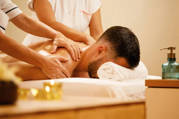 Two Female Therapists Massaging Back Man Spa Salon — 图库照片