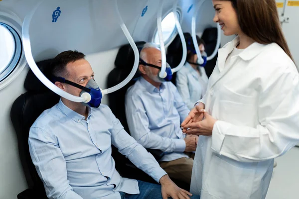 Young Happy Nurse Talking Male Patient Who Receiving Hyperbaric Oxygen — Foto de Stock