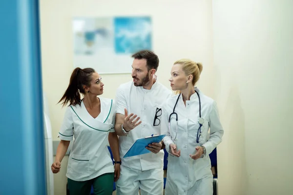 Team Healthcare Workers Talking Medical Reports While Rushing Lobby Hospital — Stockfoto