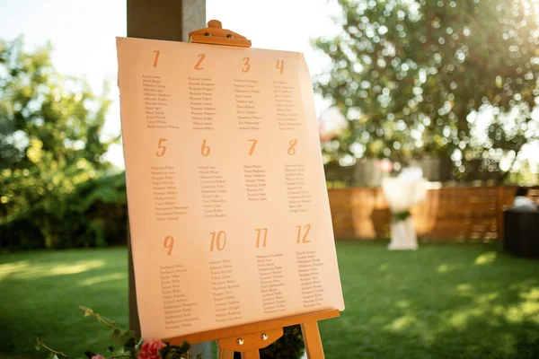 Welcome board at outdoor wedding reception.