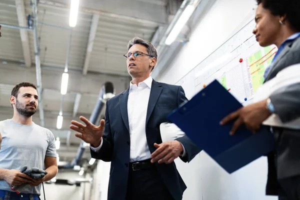 Corporate manager taking a tour in a factory and communicating with production line workers.