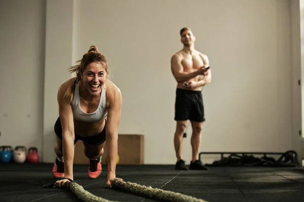 Cheerful Female Athlete Doing Push Ups While Exercising Battle Rope — Fotografia de Stock