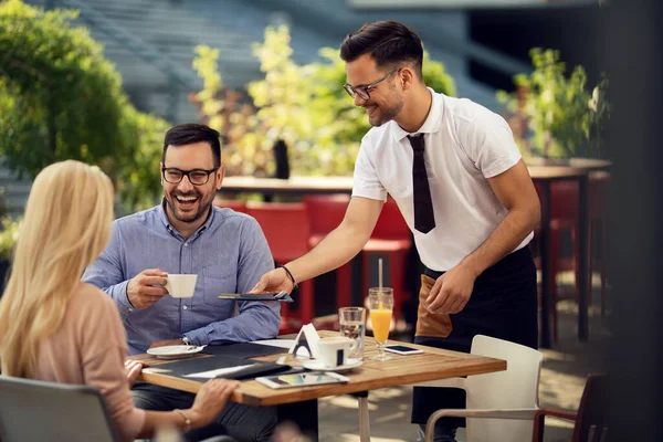 Happy Couple Talking While Waiter Setting Table Dining Giving Them — Stockfoto