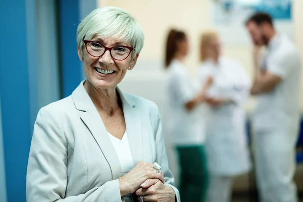 Portrait Smiling Senior Woman Looking Camera While Standing Corridor Hospital — Foto de Stock