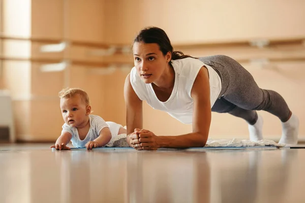 Athletic Mother Exercising Plank Position While Being Her Baby Health — Foto de Stock