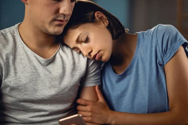 Young woman seeking for solace on boyfriend\'s shoulder while feeling sad about something.
