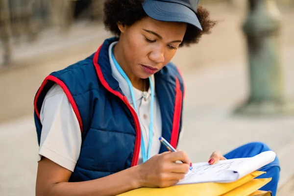 Black Delivery Woman Filling Paperwork While Sitting City Street — Stok Foto