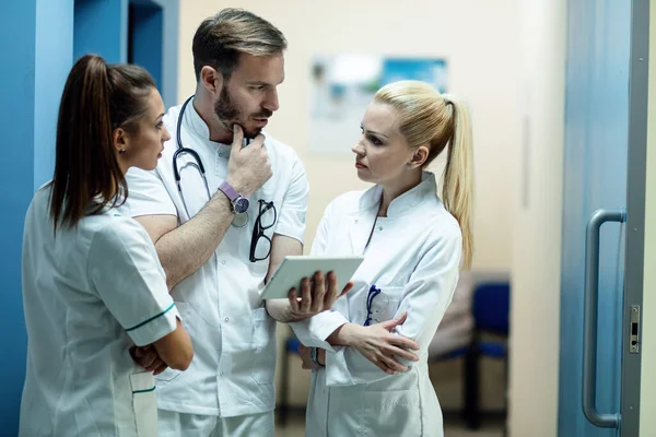 Team Doctors Discussing Patients Medical Reports While Using Digital Tablet — Foto de Stock