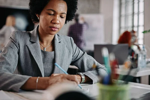 Black Businesswoman Taking Notes While Sitting Office Desk People Background — Stok fotoğraf