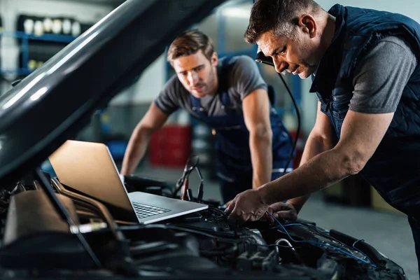 Car Repairmen Using Laptop While Doing Car Engine Diagnostic Auto — Stock Photo, Image