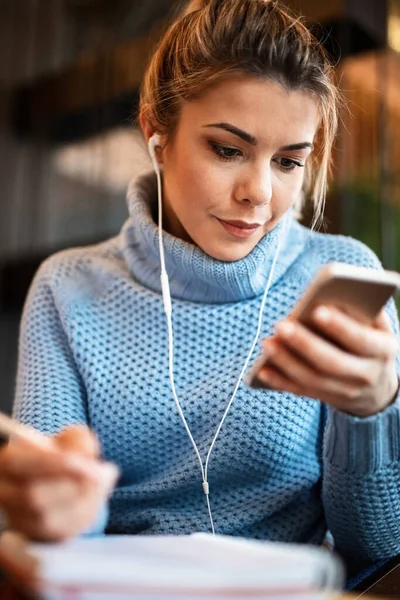 Young Female Entrepreneur Taking Notes While Reading Something Smart Phone —  Fotos de Stock