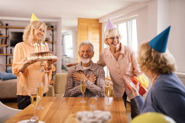 Happy Senior Women Surprising Friend Cake His Birthday Home — стоковое фото