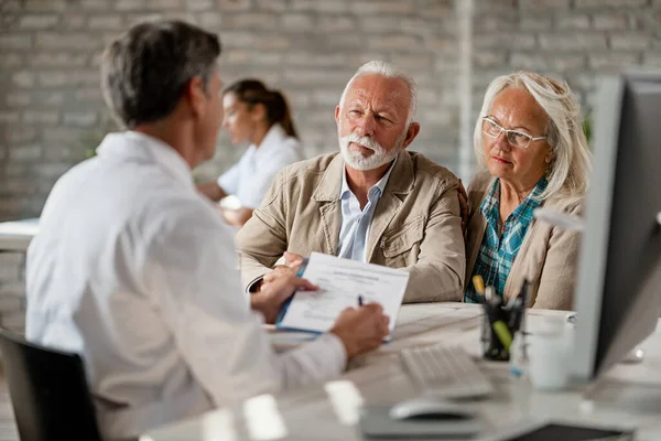 Senior Couple Consulting Healthcare Worker Insurance Policy While Having Meeting — Fotografia de Stock