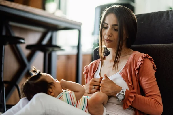 Young Mother Relaxing Her Baby Daughter Home — Foto de Stock