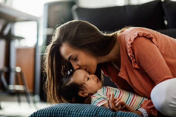 Young Loving Mother Kissing Her Baby Girl While Spending Time — Stok fotoğraf