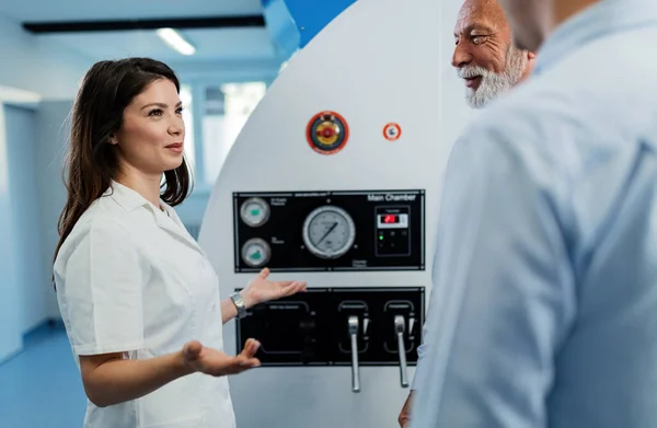 Young Happy Doctor Communicating Her Patients Front Hyperbaric Chamber Explaining — Fotografia de Stock