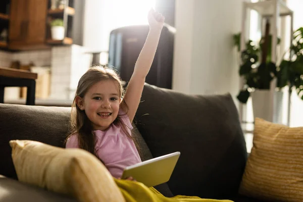 Cheerful Girl Celebrating Arm Raised While Playing Games Touchpad Living — Stockfoto