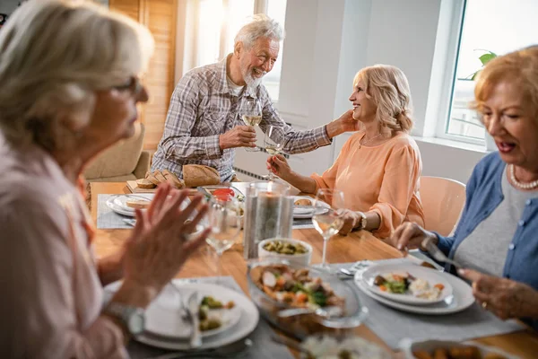 Happy Mature Couple Toasting Wineglasses Talking Lunch Time Friends Home — Foto Stock