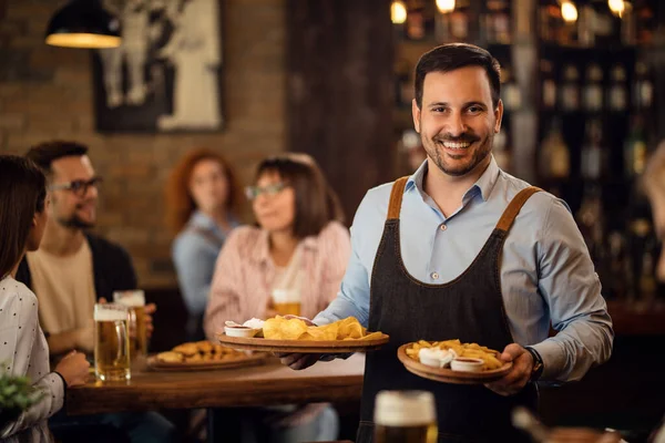 Happy Waiter Holding Plates Food Looking Camera While Serving Guests — Foto de Stock
