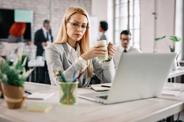 Serious Businesswoman Drinking Tea Contemplating While Working Office People Background — Stock Fotó
