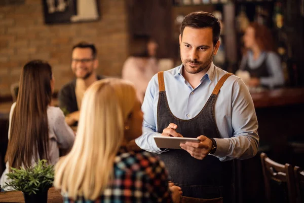 Mid Adult Waiter Using Digital Tablet Writing Order While Communicating — Stockfoto