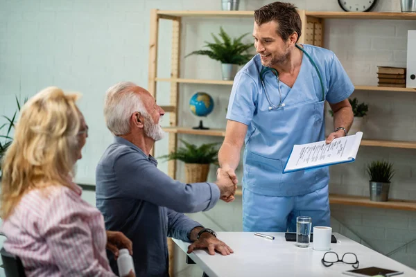 Happy Healthcare Worker Mature Couple Greeting His Office Men Shaking — Stockfoto