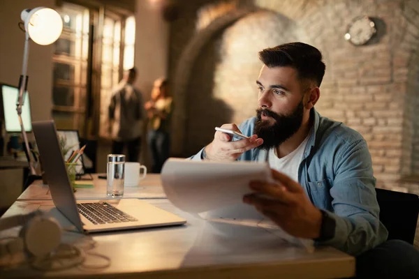 Young Businessman Talking Smart Phone Speaker While Using Laptop Analyzing — Foto de Stock