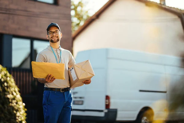 Young Courier Packages Looking Street Address While Making Home Delivery — Stockfoto