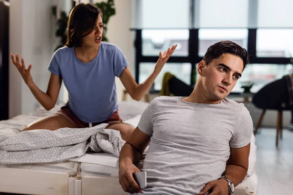 Young Man Sitting Bed Ignoring His Girlfriend Who Arguing Him — Stock Fotó