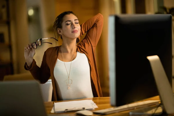 Young Woman Feeling Tired Stretching While Working Late Evening Home — Foto de Stock