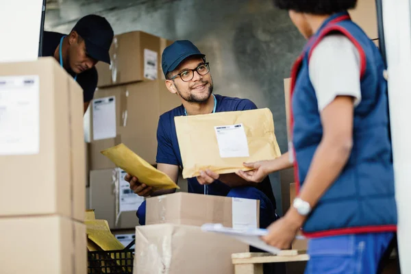 Young Happy Courier Talking His Female Coworker While Preparing Packages — Foto Stock