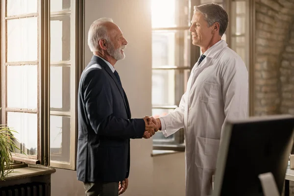 Happy Mature Businessman Male Doctor Handshaking While Greeting Clinic — Stockfoto