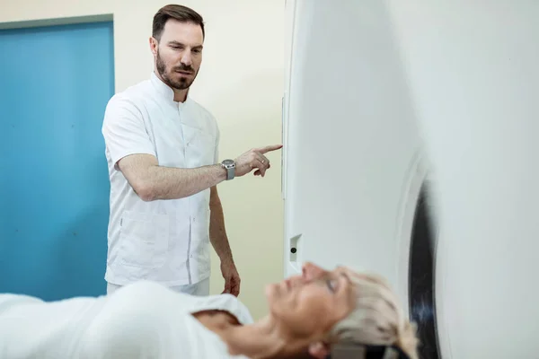 Male Radiologist Starting Scan Procedure Female Patient Medical Examination Room — Stockfoto